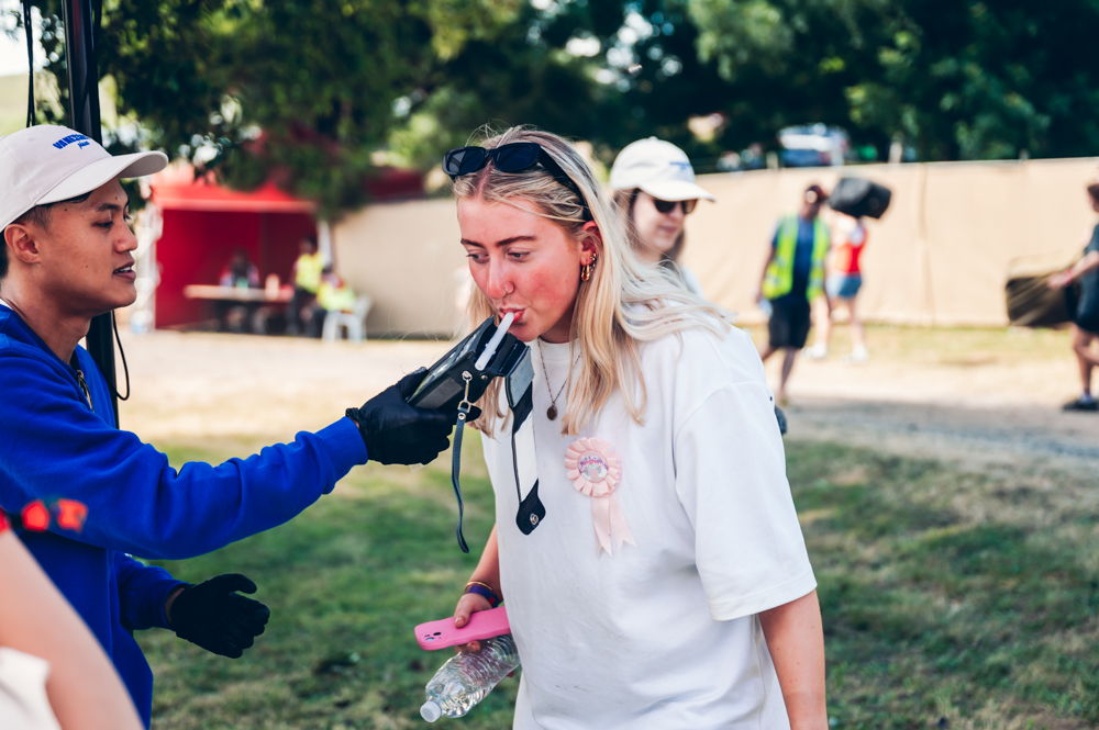 Young woman blowing into breathaliser